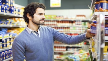 Man reading product label in store