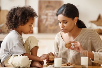 mon and child enjoy milk and cookies