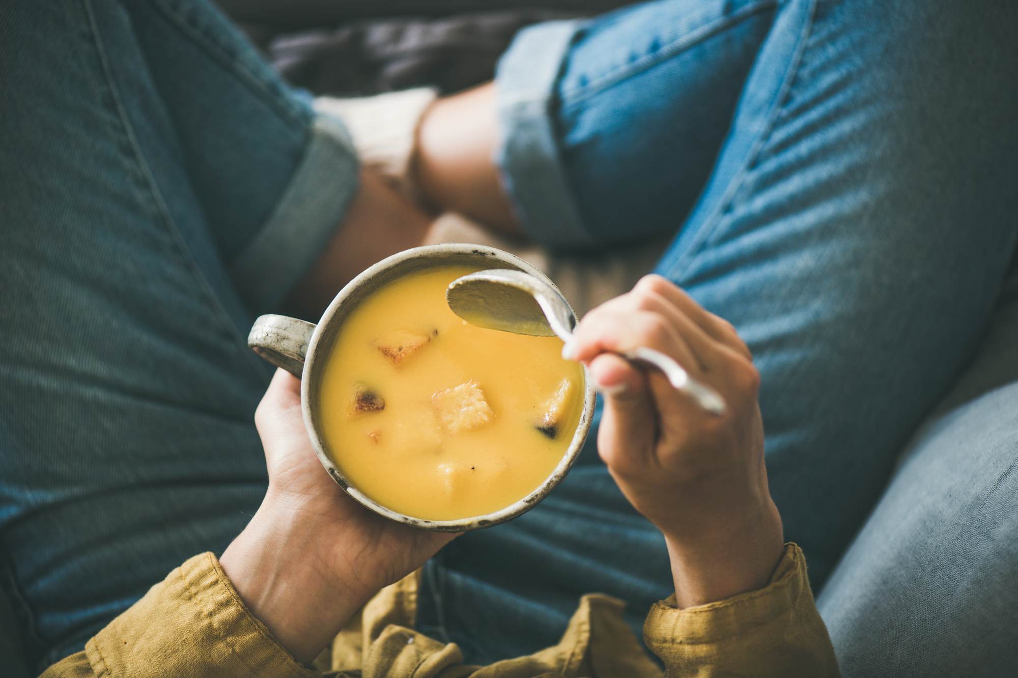 top-view-of-a-bowl-of-soup-being-held-by-a-person-sitting-cross-legged